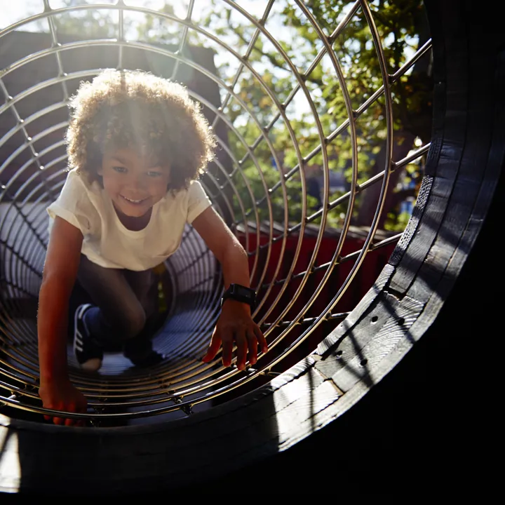Child crawling through tunnel in Castaway Camp