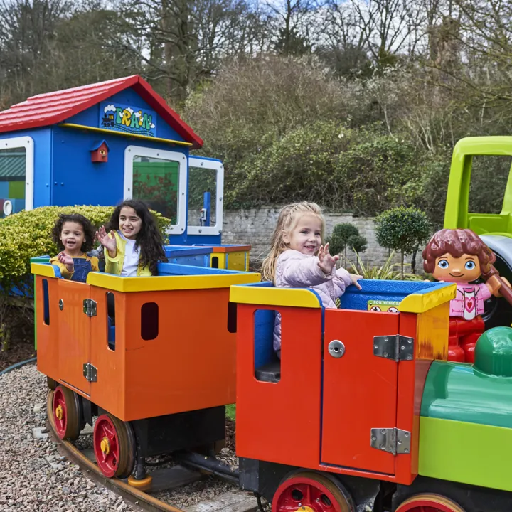 3 girls smiling and waving on DUPLO Train