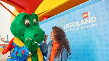 Girl laughing with Ollie the Dragon at the LEGOLAND Windsor Resort