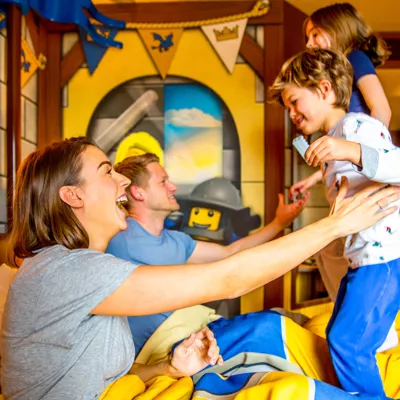 Children bouncing on bed in Knight's Room at LEGOLAND Castle Hotel