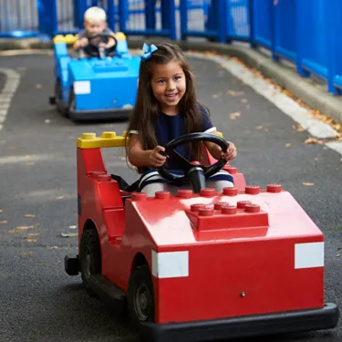 Girl and boy driving cars at L-Drivers at the LEGOLAND Windsor Resort