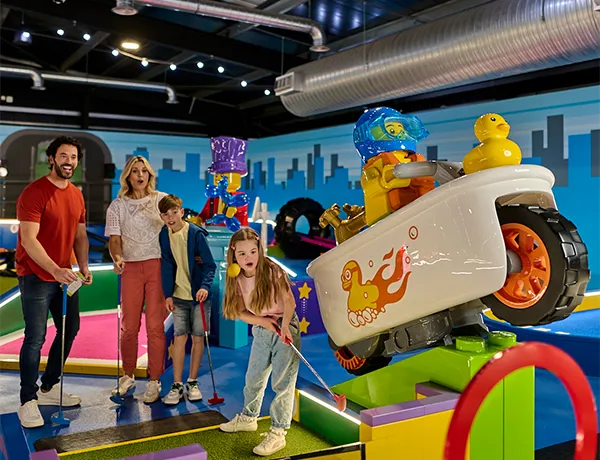 Family playing LEGO City course at LEGOLAND Adventure Golf in Windsor, the world's first indoor LEGO golf experience