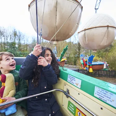 Girl and boy looking up and smiling on Balloon School at the LEGOLAND Windsor Resort