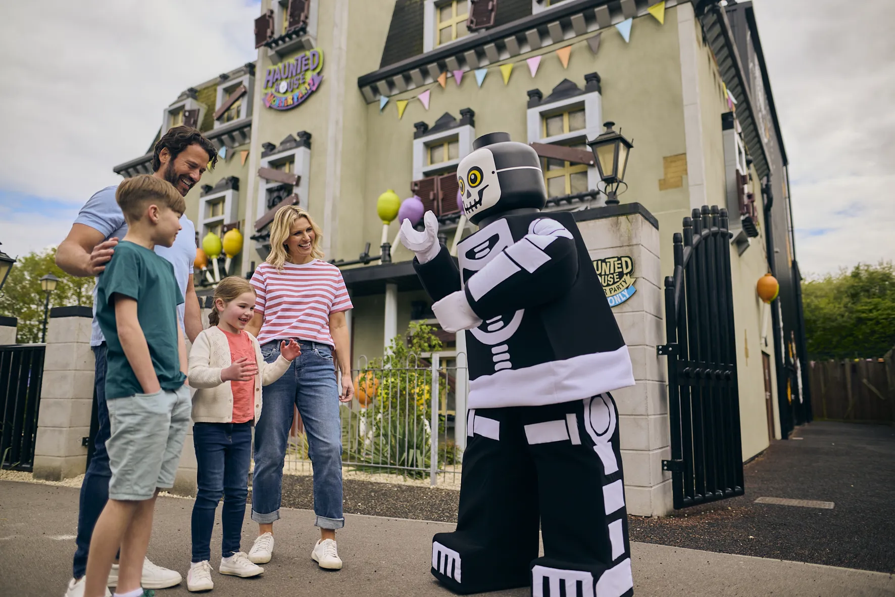 Family meeting Skeleton Guy outside of Haunted House Monster Party