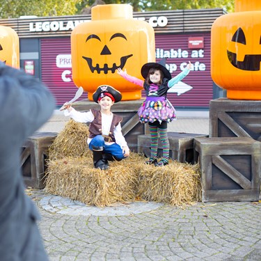 Parents taking photo of children next to large Pumpkin minifigure heads at Brick or Treat at the LEGOLAND Windsor Resort