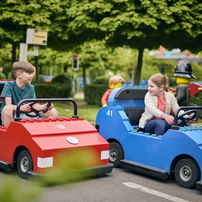 2 children driving LEGO cars