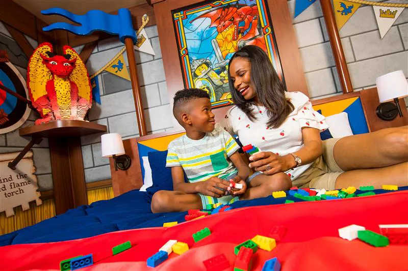 Mother and son on a bed in the LEGOLAND Castle Hotel playing with LEGO