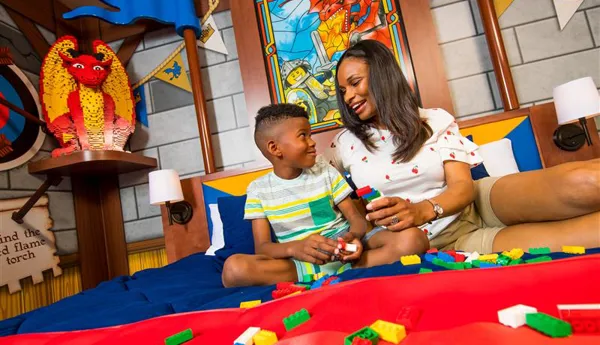 Mother and son on a bed in the LEGOLAND Castle Hotel playing with LEGO