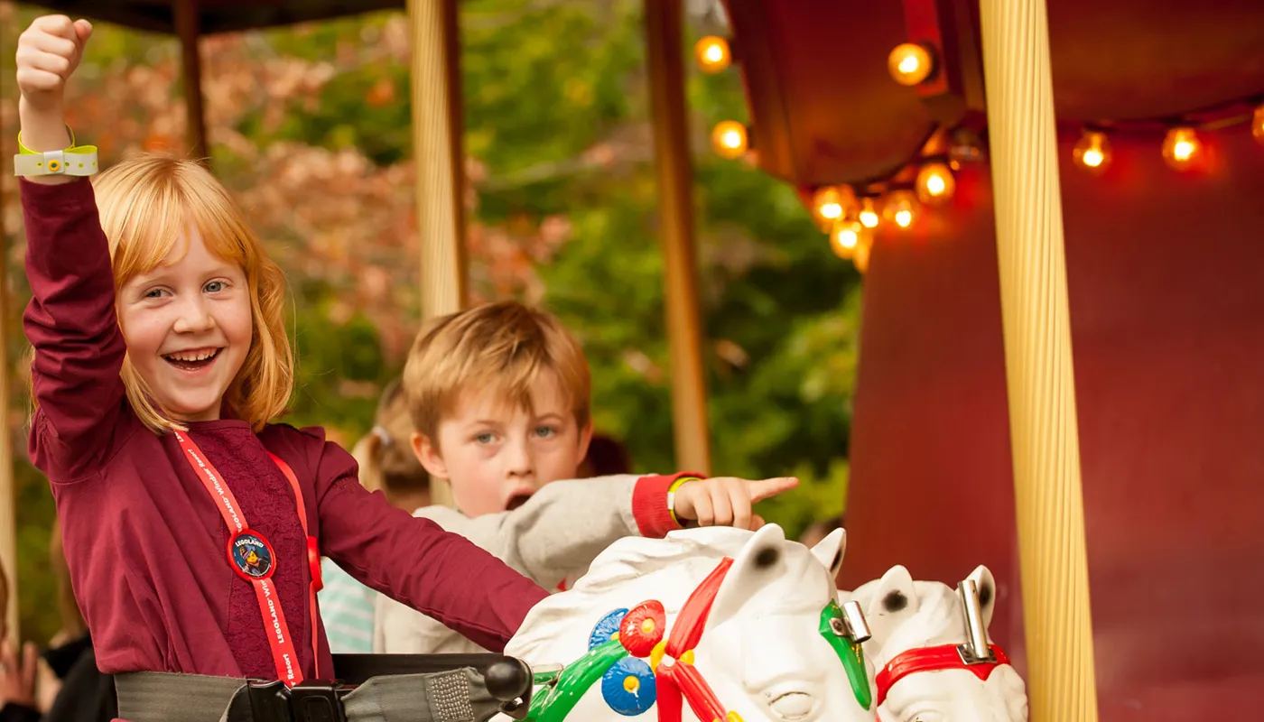 Boy and girl riding Desert Chase carousel