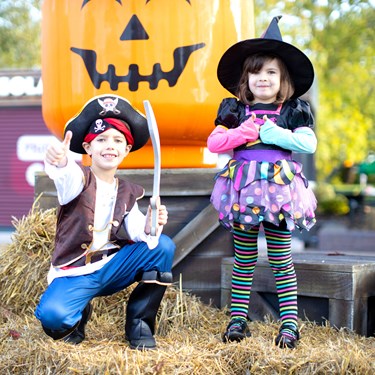 Children next to large Pumpkin minifigure heads at Brick or Treat at the LEGOLAND Windsor Resort