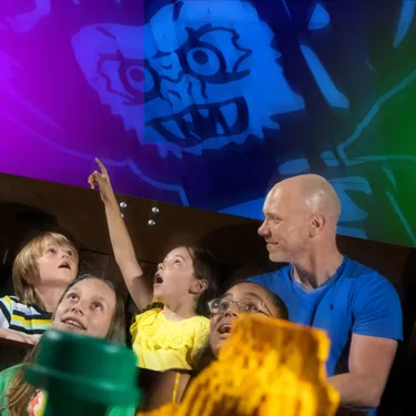 Girl pointing with family inside Haunted House Monster Party at the LEGOLAND Windsor Resort