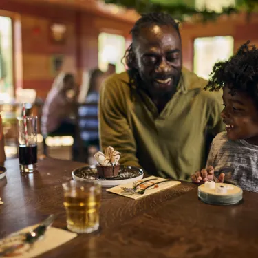 Family Eating At Clubhouse Restaurant At Woodland Village