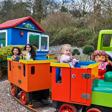 3 girls smiling and waving on DUPLO Train