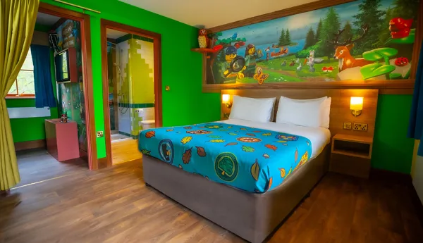 The interior of a Woodland Village Standard Lodge, including double bed, separate children's sleeping area and bathroom at LEGOLAND Windsor