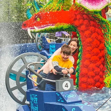 Adult & child getting splashed on Hydra's Challenge in LEGO MYTHICA