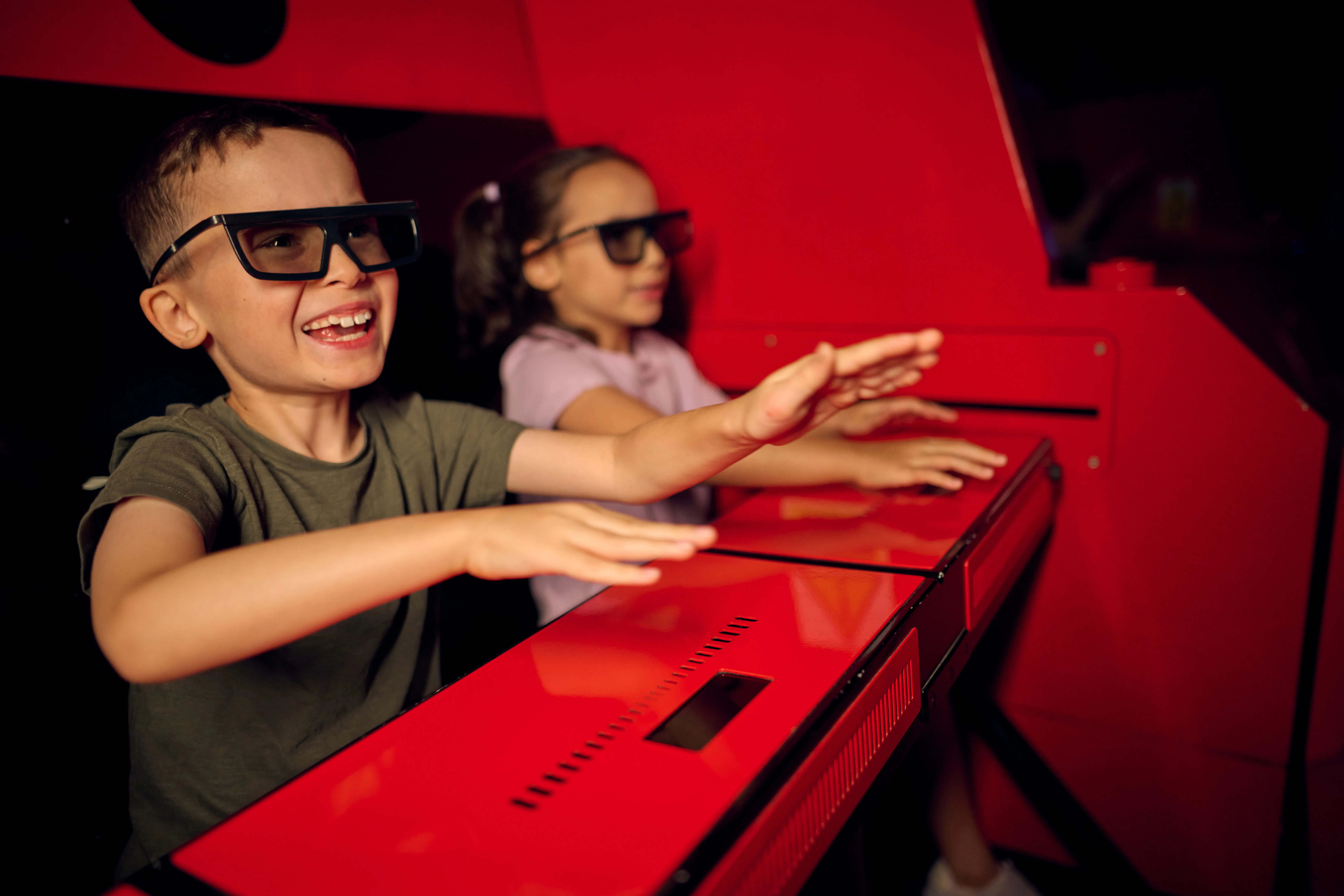 Boy and girl enjoying LEGO NINJAGO The Ride wearing 3D glasses