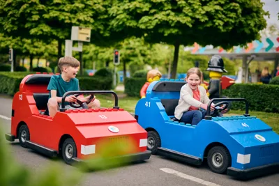 Boy And Girl Driving Cars At LEGO City Driving School At The LEGOLAND Windsor Resort