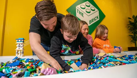Families building with LEGO bricks in The Brick