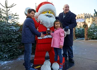 Family with LEGO model of Father Christmas at LEGOLAND at Christmas at the LEGOLAND Windsor Resort