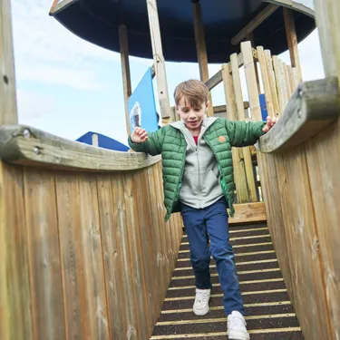 Boy crossing wooden bridge in DUPLO Playtown
