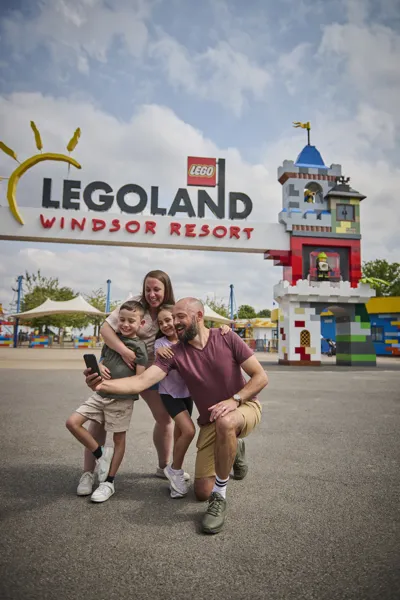 A Family Taking A Selfie Outside Of The Entrance Portal At The LEGOLAND Windsor Resort