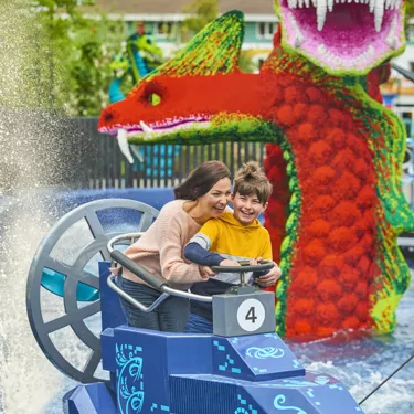 Adult & child getting splashed on Hydra's Challenge in LEGO MYTHICA