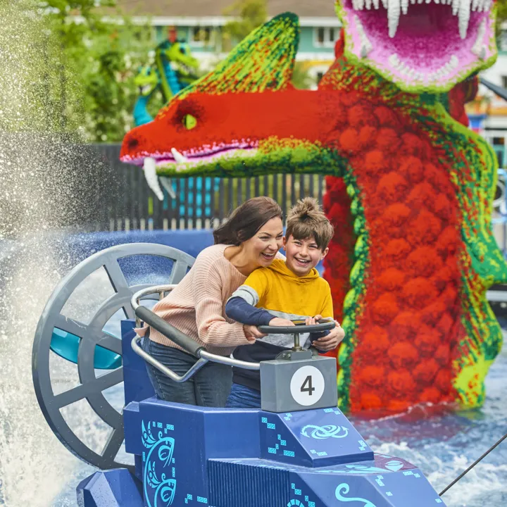 Adult & child getting splashed on Hydra's Challenge in LEGO MYTHICA
