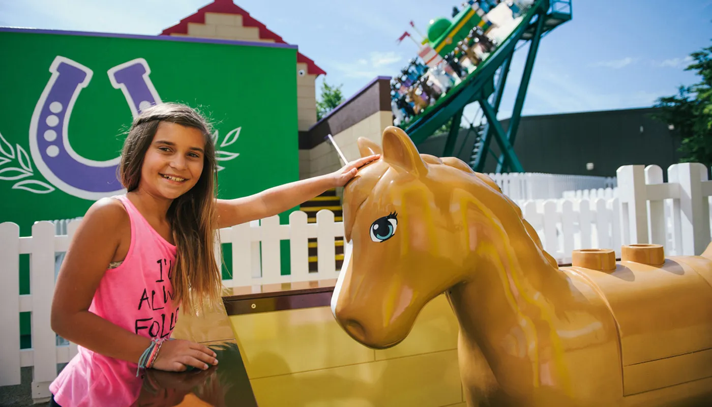 Girl stroking model horse at Mia's Riding Adventure