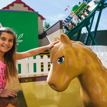 Girl stroking model horse at Mia's Riding Adventure