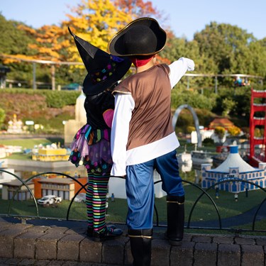 Children in Halloween costumes pointing at landmarks in Miniland at Brick or Treat at the LEGOLAND Windsor Resort