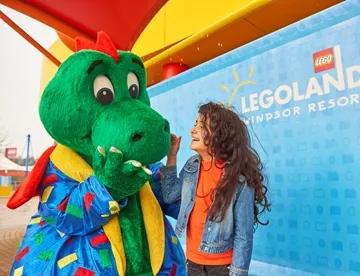 Girl laughing with Ollie the Dragon at the LEGOLAND Windsor Resort