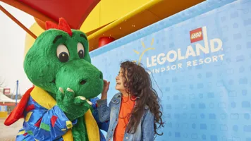 Girl laughing with Ollie the Dragon at the LEGOLAND Windsor Resort