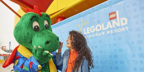 Girl laughing with Ollie the Dragon at the LEGOLAND Windsor Resort