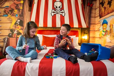 Children building LEGO on a bed in Pirate Room at LEGOLAND Resort Hotel