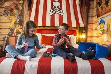 Children building LEGO on a bed in Pirate Room at LEGOLAND Resort Hotel