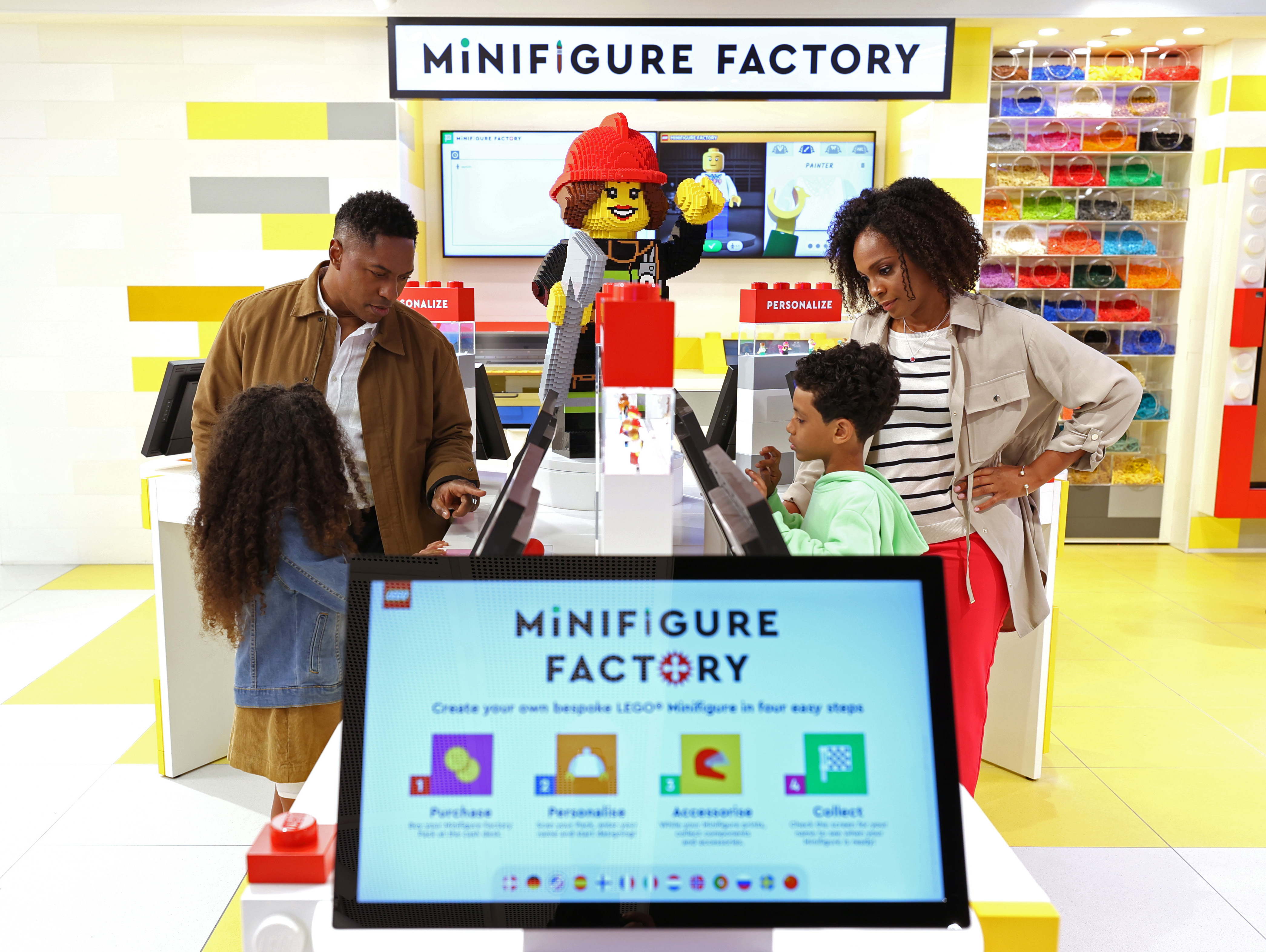 Family building Minifigures at the Minifigure Factory at The LEGO Store
