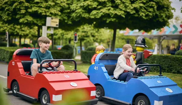 Boy and Girl driving LEGO cars at LEGO City Driving School