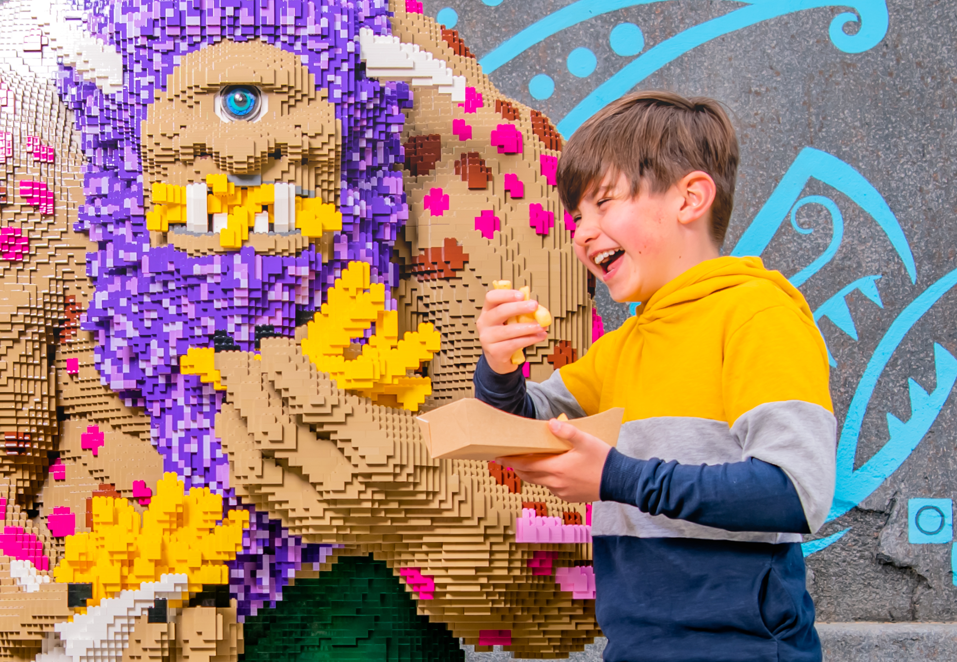 Child enjoying Chips next to LEGO® Troll at The Hungry Troll restaurant