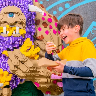 Child enjoying Chips next to LEGO® Troll at The Hungry Troll restaurant