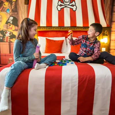 Boy and girl playing with LEGO in a Premium Pirate room at the LEGOLAND Resort Hotel
