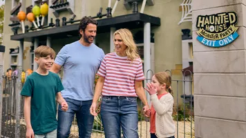 Family laughing outside of Haunted House Monster Party building