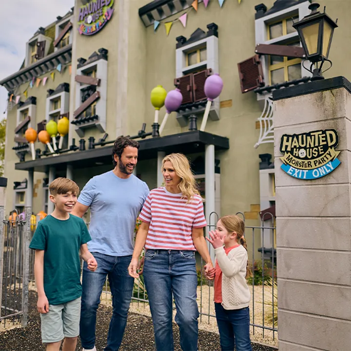 Family laughing outside of Haunted House Monster Party building