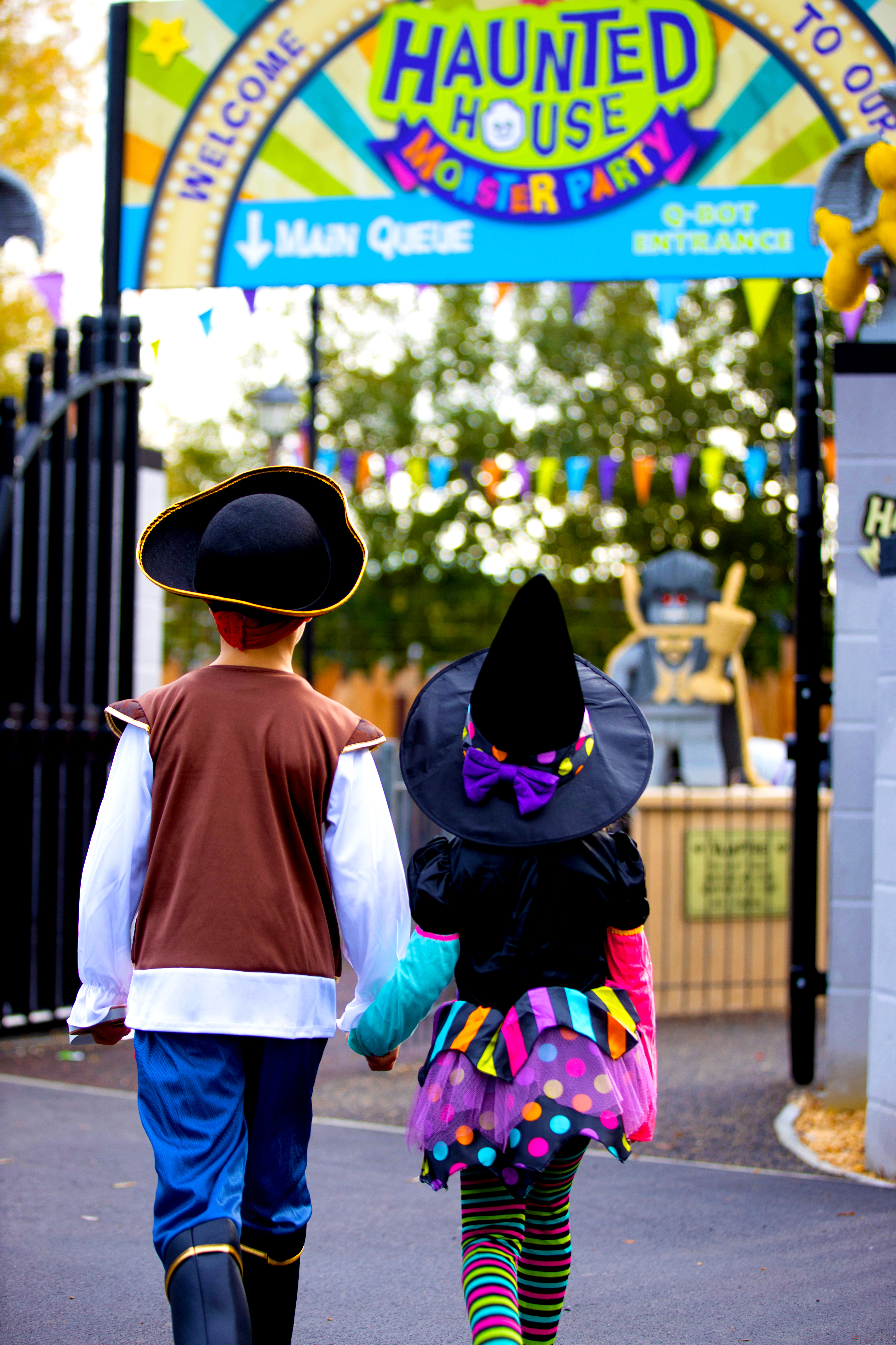 Back of children in Halloween costumes walking towards Haunted House Monster Party during Brick or Treat at the LEGOLAND Windsor Resort