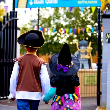 Back of children in Halloween costumes walking towards Haunted House Monster Party during Brick or Treat at the LEGOLAND Windsor Resort