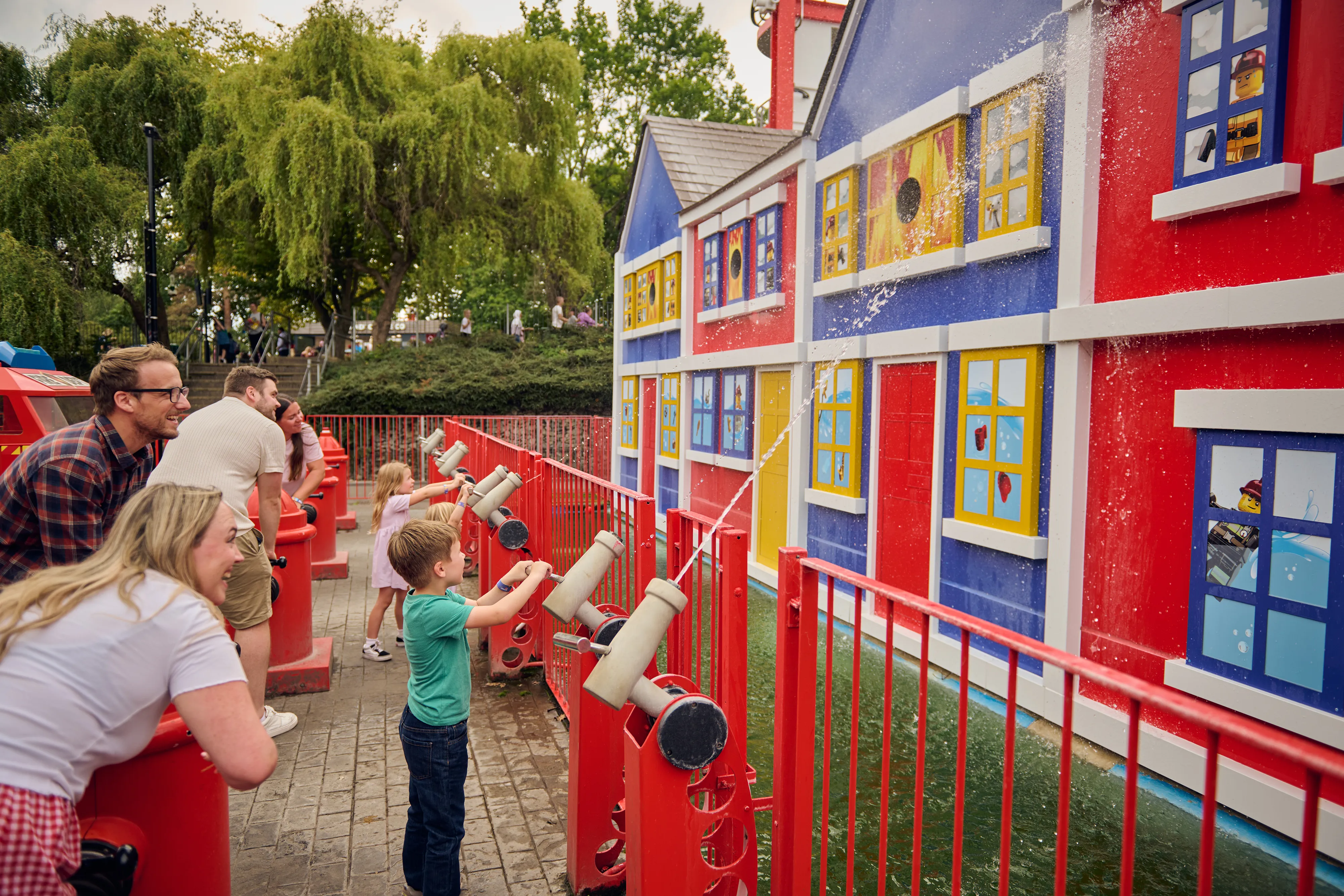 Families using water cannons to shoot water at a building on Fire Academy
