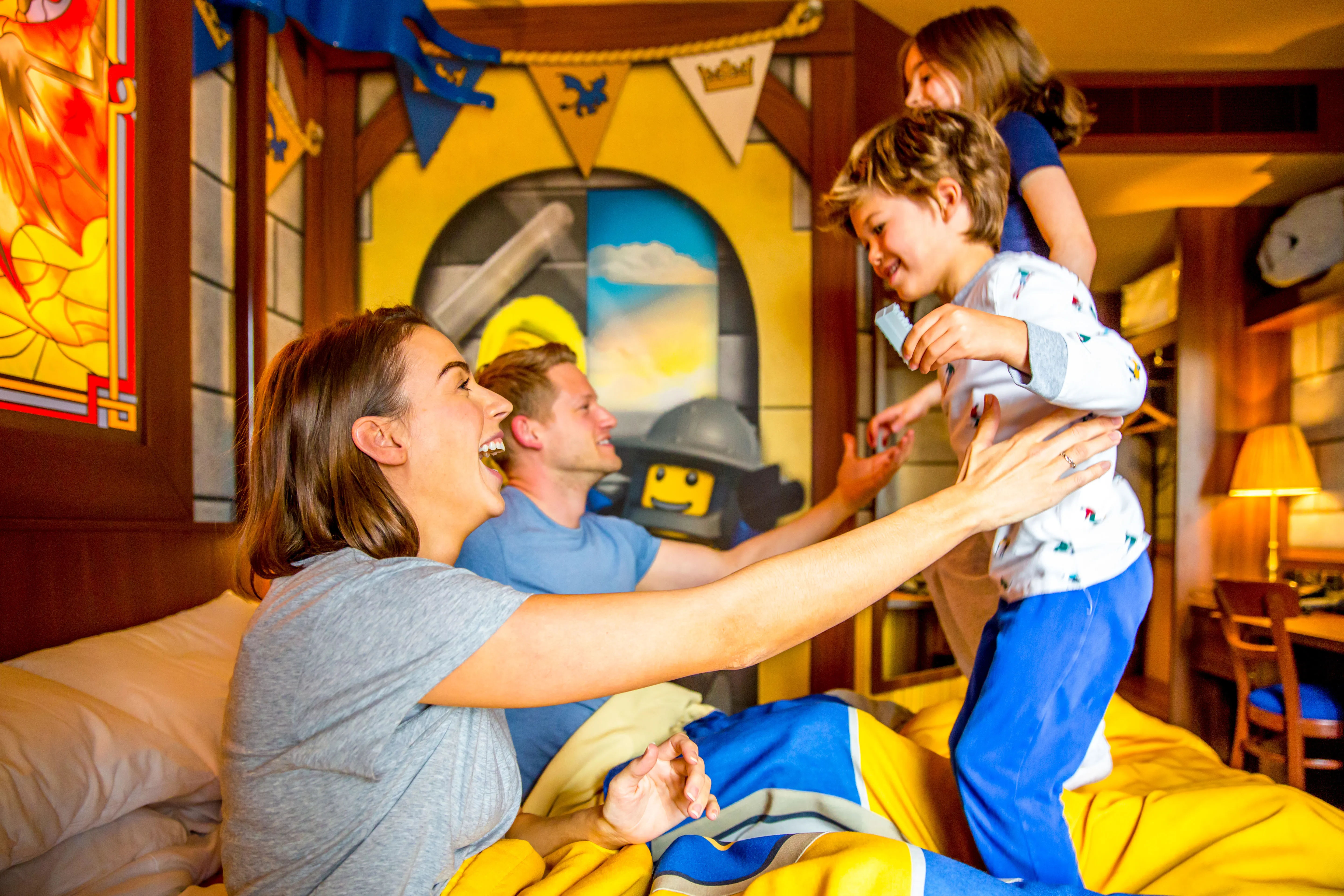 Children bouncing on bed in Knight's Room at LEGOLAND Castle Hotel