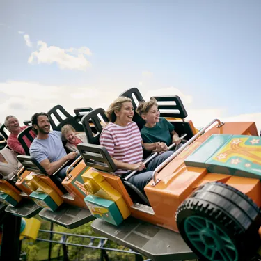 Family smiling riding Minifigure Speedway at the LEGOLAND Windsor Resort