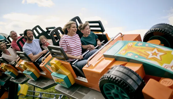 Family smiling riding Minifigure Speedway at the LEGOLAND Windsor Resort