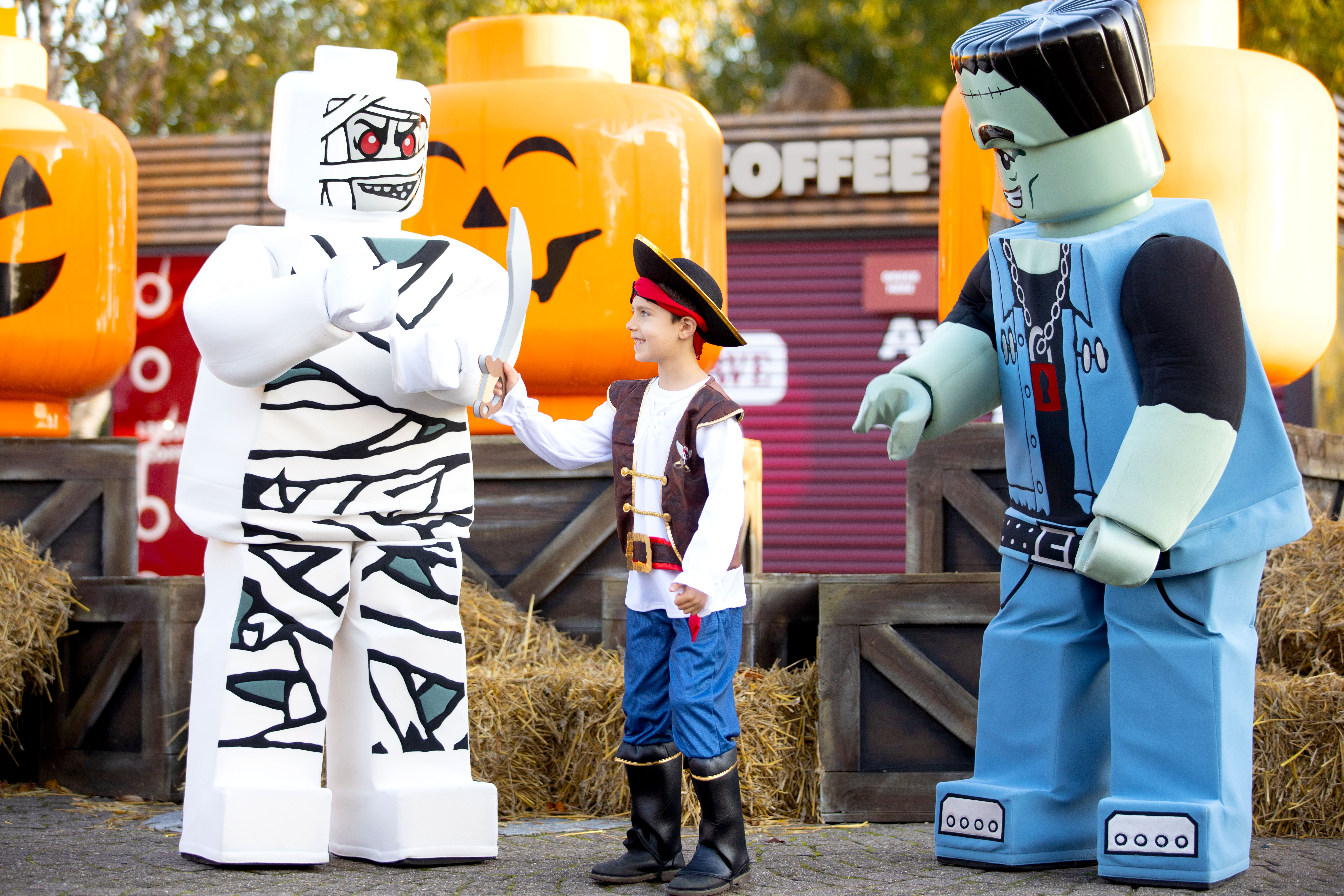 Boy with Mummy and Monster Rocker in front of Pumpkin minifigure heads at Brick or Treat at the LEGOLAND Windsor Resort