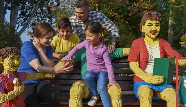 Family sat on bench using LEGOLAND Windsor app